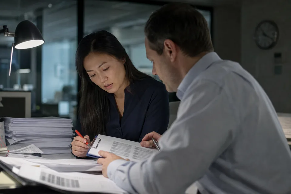 A finance team checking a printed earnings release draft against a sign off checklist