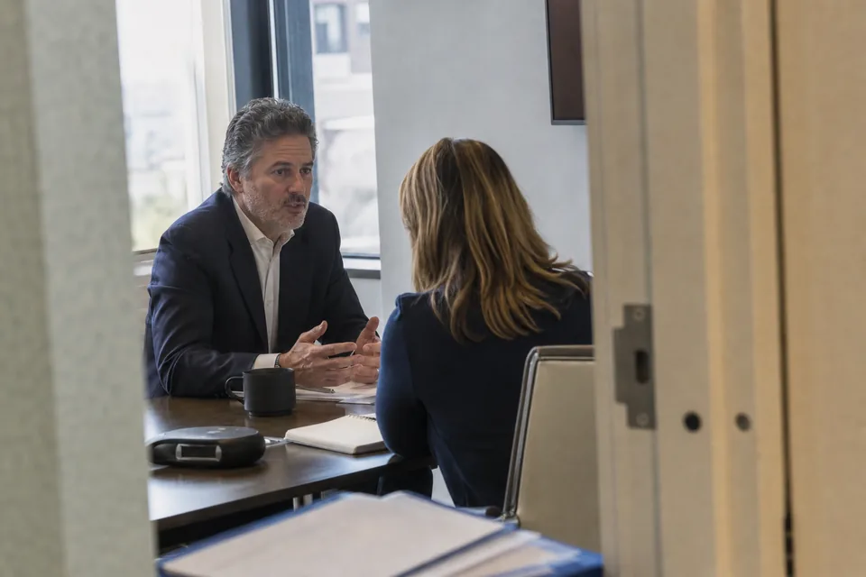 A company executive meeting a portfolio manager one on one in an office meeting room