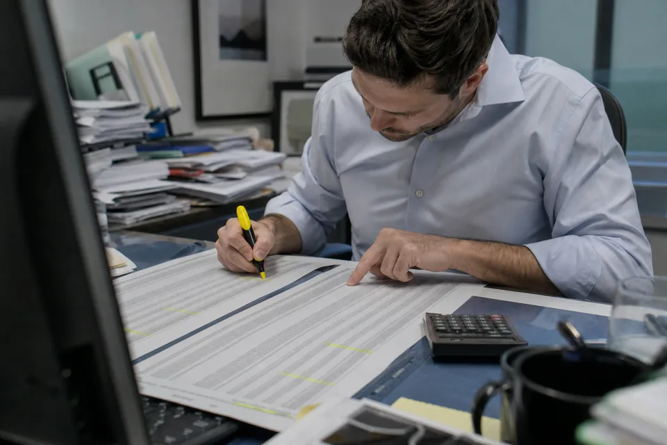 An IR analyst comparing two printed shareholder register snapshots with a highlighter