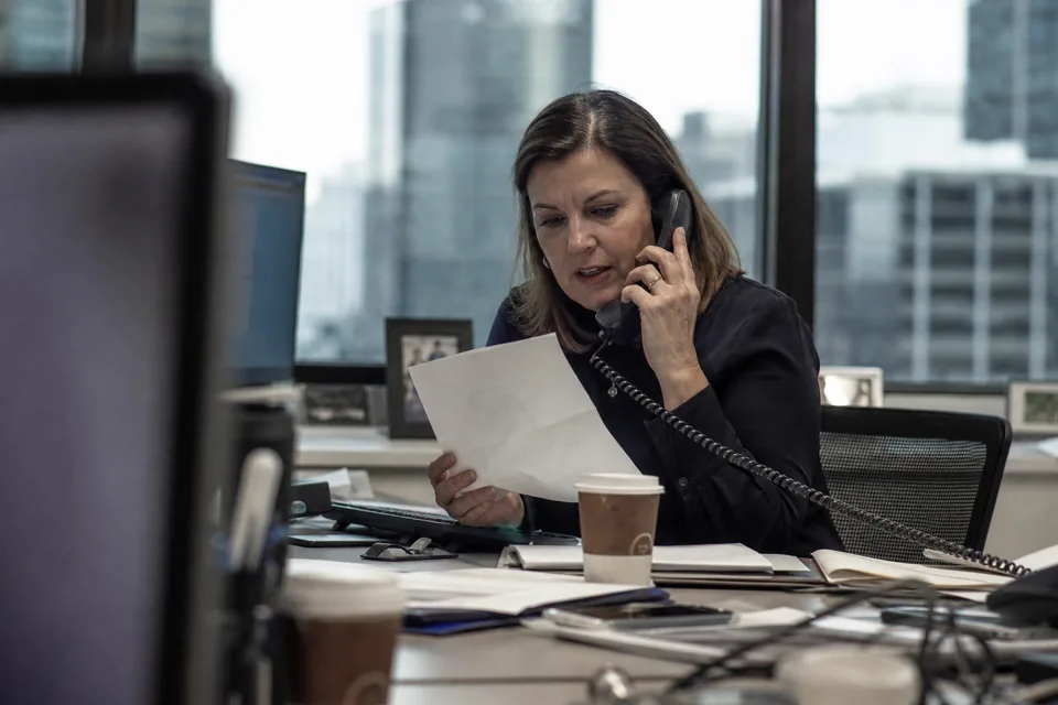 Corporate treasurer reviewing bond maturities and debt investor notes in a meeting room