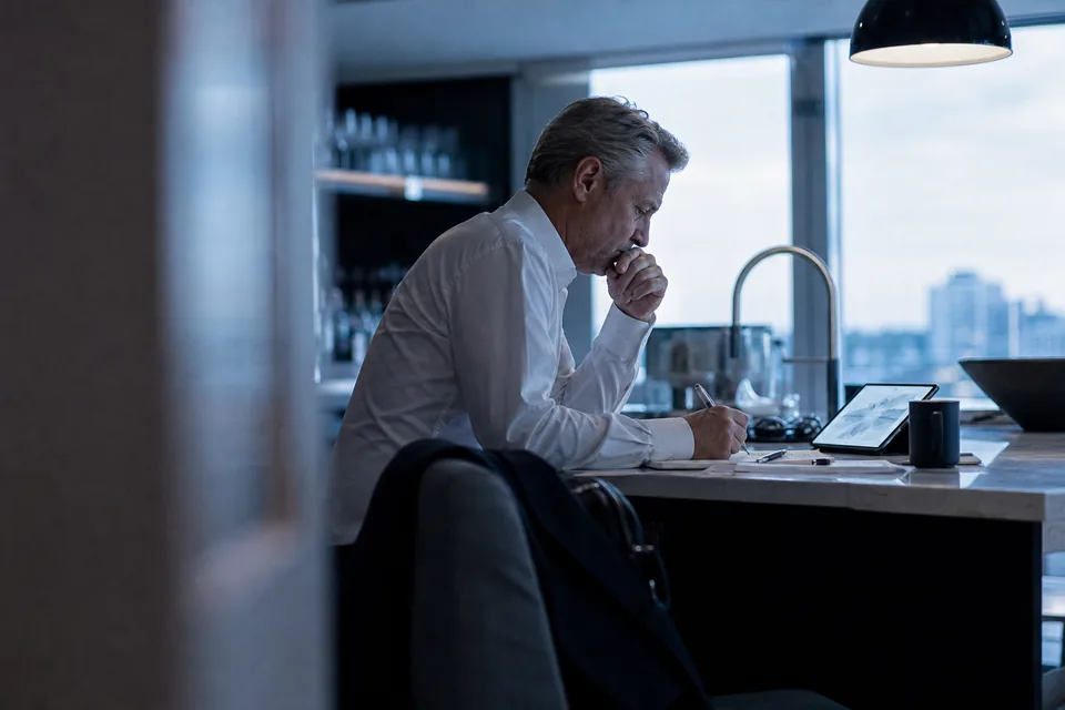 A CEO preparing early in the morning with a tablet and notes before investor meetings