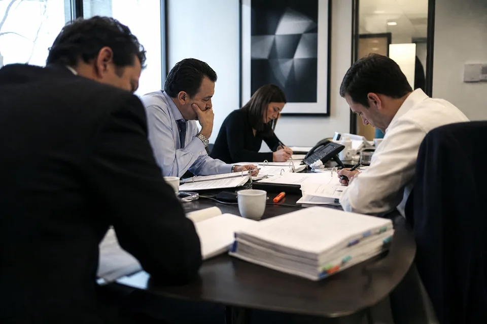 A deal team around a table with offering memorandum binders preparing a capital raise