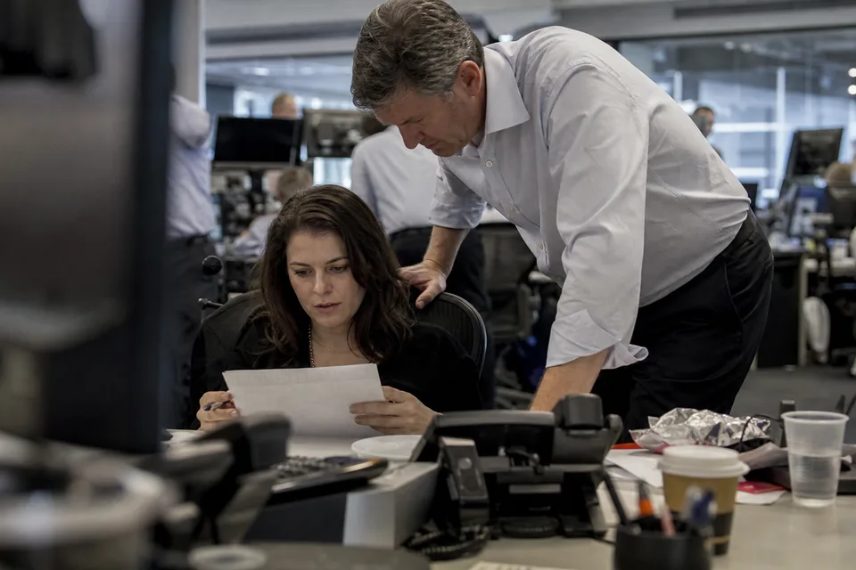 Corporate treasurer comparing bond yields and maturities on two monitors in a treasury office