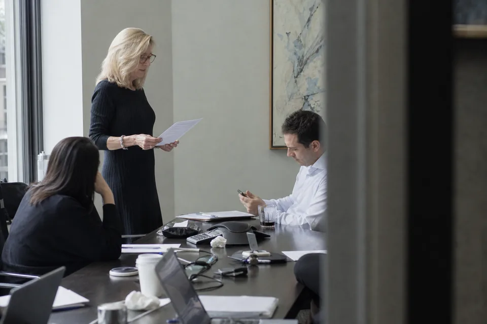An investor relations team rehearsing the earnings call script in a conference room
