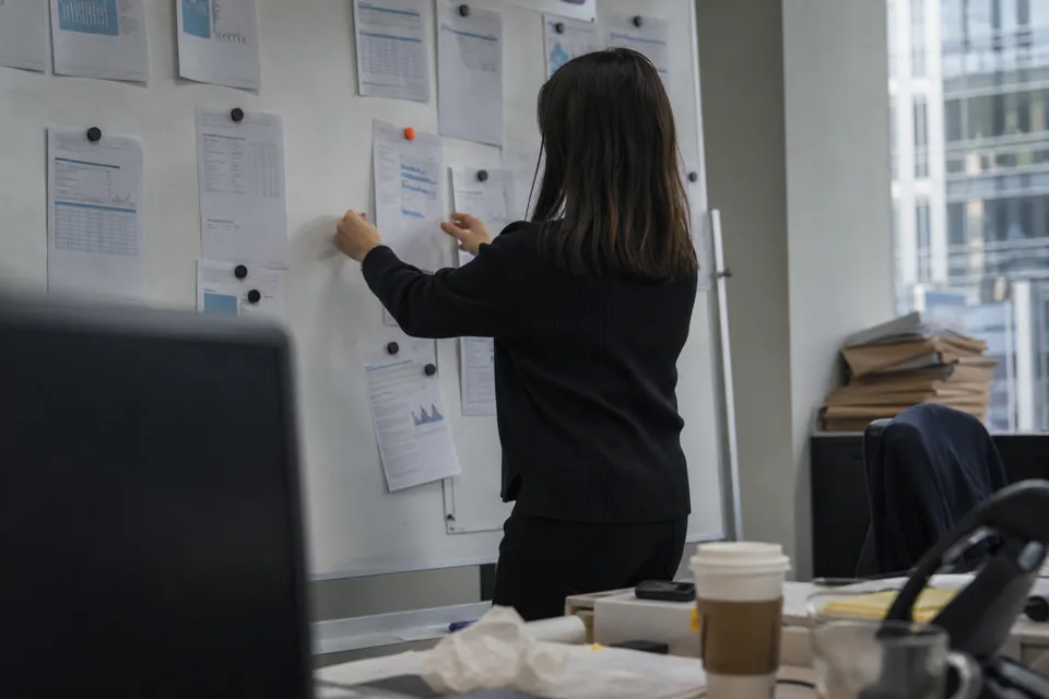 A CFO planning the quarter's investor meetings at a desk with printed schedules